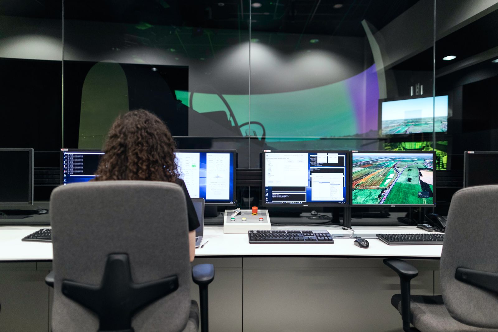 Salle de supervision : analyste face à un mur d'écrans de monitoring